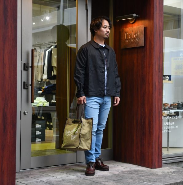 ENTRE AMIS アントレアミ のブルーウォッシュ加工のデニムパンツに、ブラウンのレザーシューズと、長袖の白いTシャツに黒のリネンジャケットをフレンチカジュアルでコーディネートした写真