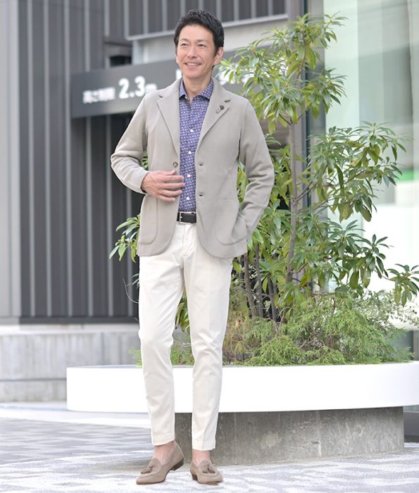 明るめベージュのジャケットを使った冬のビジネスカジュアルコーディネート。白パンツとローファーで軽やかにまとめた大人の着こなし。
