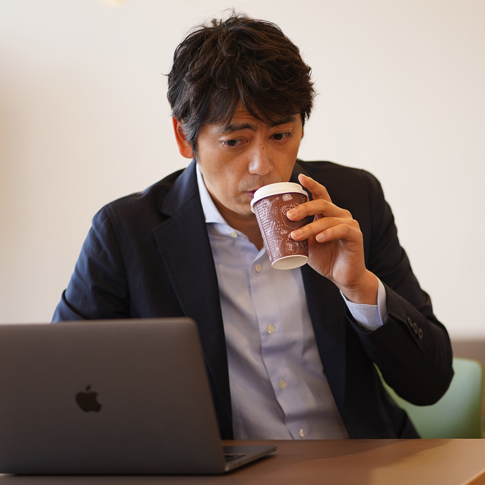 スローウェア　テクノサルトリアル　ジャケット　コーヒーを飲む男性モデル