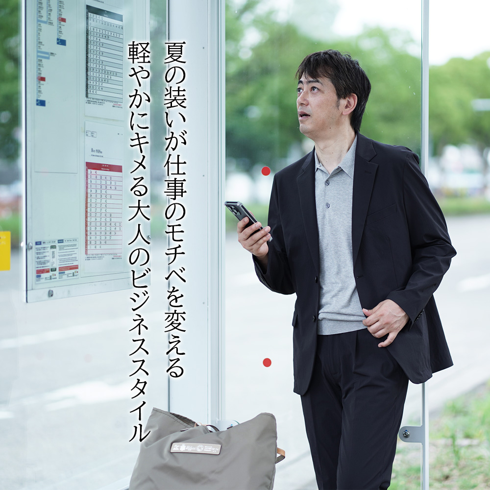 夏の装いが仕事のモチベを変える　軽やかにキメる大人のビジネススタイル　スマホ片手にバスの時刻表を眺めている風景
